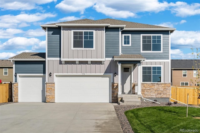 view of front of home with driveway, fence, board and batten siding, and stone siding