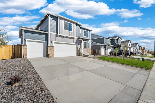 view of front of home with fence, a residential view, board and batten siding, concrete driveway, and a garage