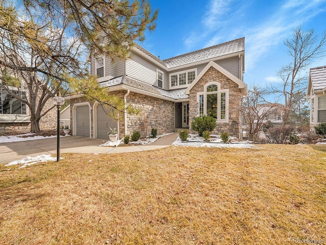 view of front facade with stone siding, a front yard, concrete driveway, and a garage