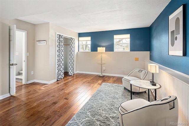 sitting room featuring hardwood / wood-style floors and wainscoting