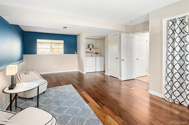 living area featuring washer and dryer, visible vents, baseboards, and hardwood / wood-style floors