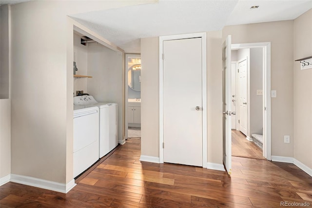 laundry area with independent washer and dryer, laundry area, baseboards, and hardwood / wood-style flooring