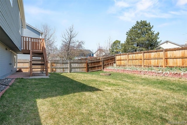 view of yard featuring a fenced backyard and stairs
