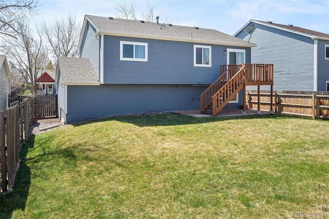 back of house featuring stairs, a fenced backyard, and a lawn