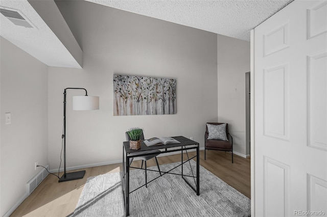 home office with wood finished floors, baseboards, and a textured ceiling