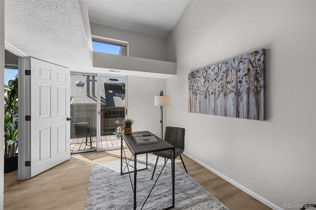 office area with wood finished floors, baseboards, and healthy amount of natural light