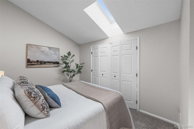 bedroom with a skylight, carpet, lofted ceiling, baseboards, and a closet