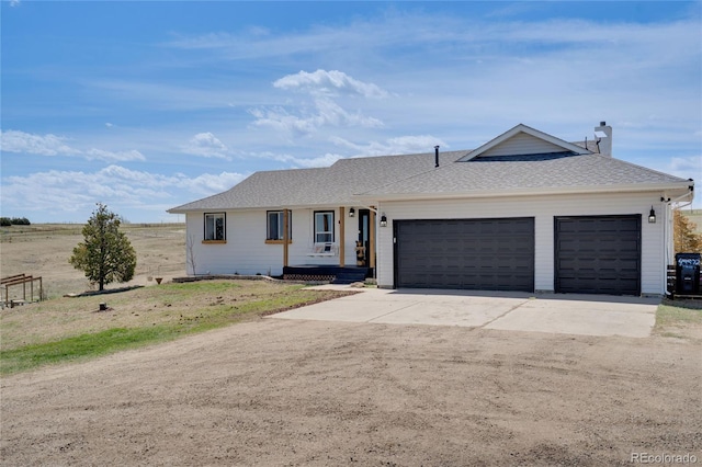 ranch-style home featuring central AC unit, concrete driveway, covered porch, an attached garage, and roof with shingles