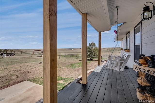 wooden terrace featuring fence and a rural view