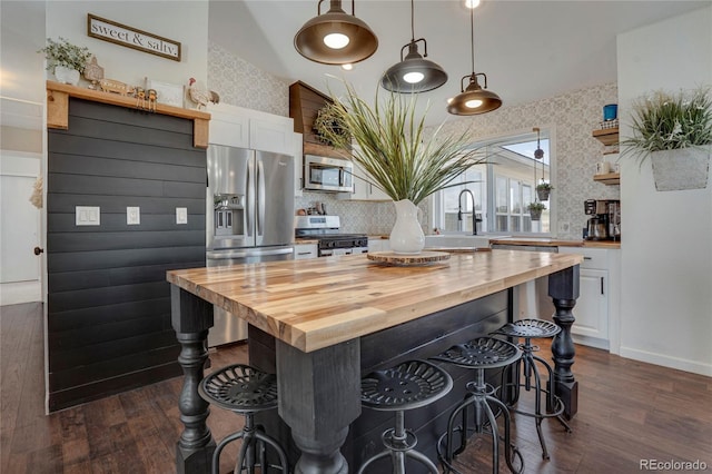 kitchen featuring white cabinets, butcher block counters, dark wood-type flooring, and stainless steel appliances