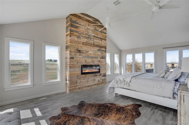 bedroom featuring visible vents, high vaulted ceiling, wood finished floors, ceiling fan, and a fireplace