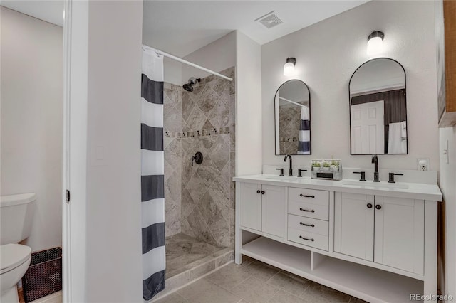 full bathroom featuring visible vents, a sink, a tile shower, and toilet