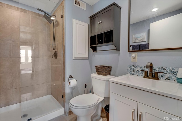 full bath featuring toilet, vanity, visible vents, and a stall shower
