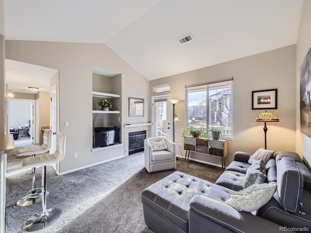 living area featuring visible vents, a tiled fireplace, lofted ceiling, dark colored carpet, and built in shelves