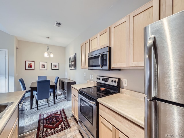 kitchen featuring visible vents, an inviting chandelier, stainless steel appliances, light countertops, and light brown cabinets