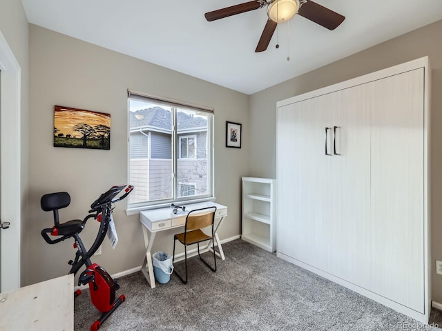 carpeted home office featuring a ceiling fan and baseboards