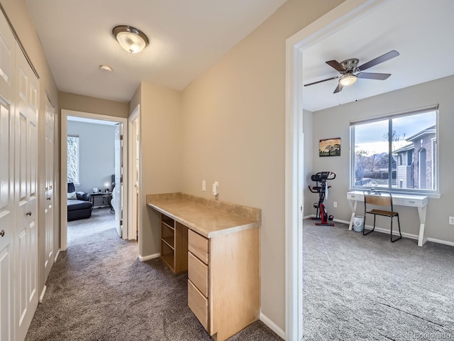 hallway with carpet floors and baseboards