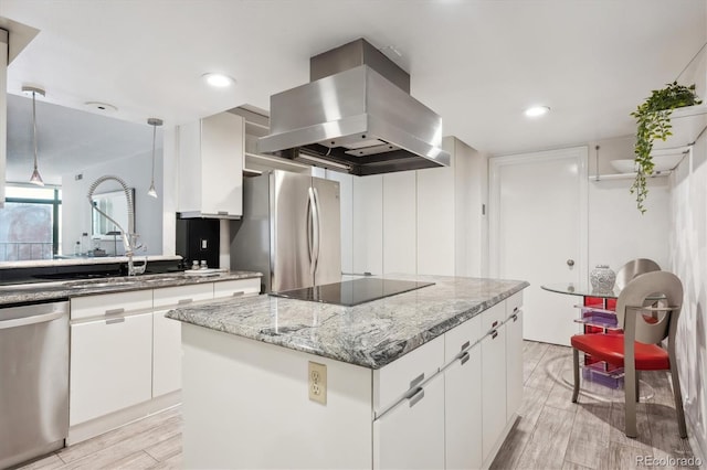 kitchen with appliances with stainless steel finishes, island range hood, white cabinetry, and a kitchen island