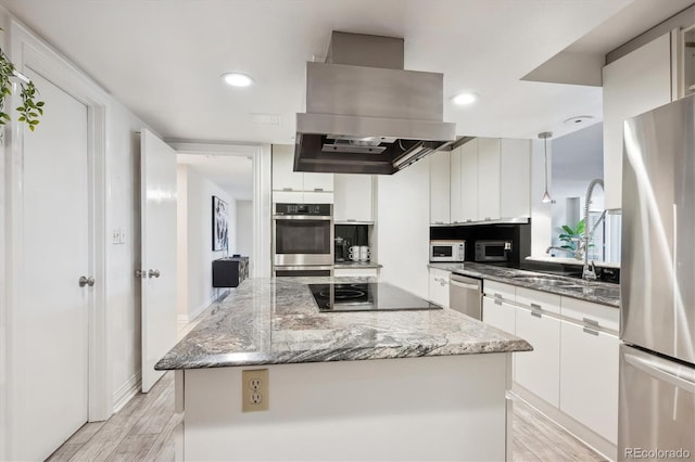 kitchen featuring ventilation hood, a kitchen island, appliances with stainless steel finishes, light hardwood / wood-style floors, and white cabinetry