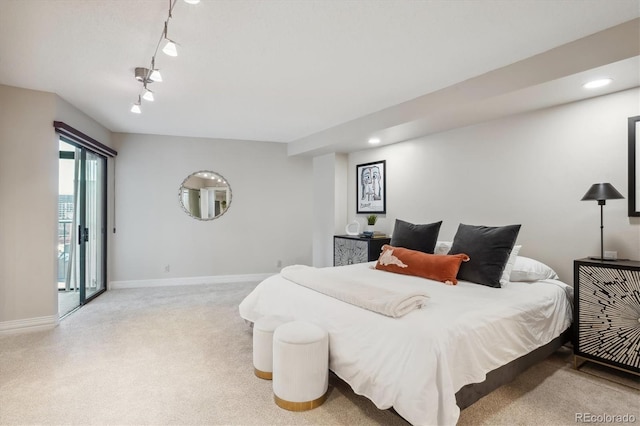 bedroom featuring rail lighting and light colored carpet