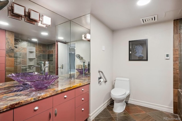 bathroom featuring vanity, toilet, and a tile shower