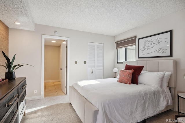 bedroom featuring light colored carpet, a textured ceiling, and a closet