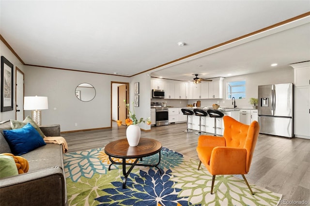 1134 Buffalo Run Rd, Calhan, CO 80808 - living room featuring light wood-type flooring, crown molding, baseboards, ceiling fan, and recessed lighting