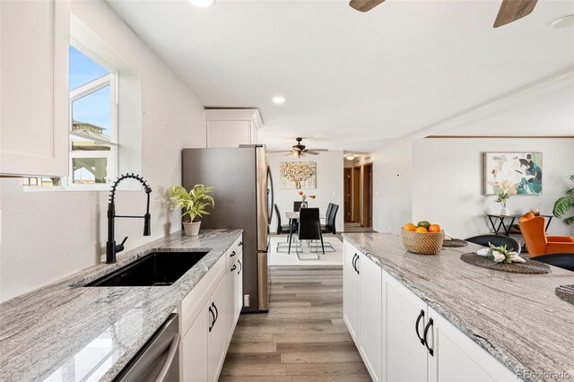 1134 Buffalo Run Rd, Calhan, CO 80808 - kitchen with ceiling fan, a sink, light wood-style floors, white cabinetry, and light stone countertops