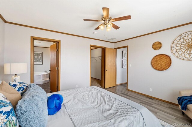 1134 Buffalo Run Rd, Calhan, CO 80808 - bedroom featuring wood finished floors, ornamental molding, baseboards, a spacious closet, and connected bathroom