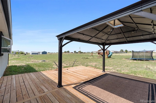 1134 Buffalo Run Rd, Calhan, CO 80808 - wooden terrace featuring a gazebo, a trampoline, a yard, and a view of rural / pastoral area