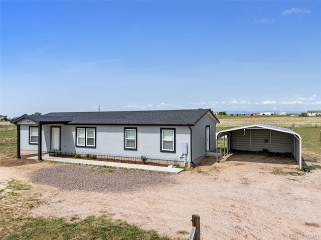1134 Buffalo Run Rd, Calhan, CO 80808 - single story home with a detached carport, dirt driveway, a shingled roof, and stucco siding