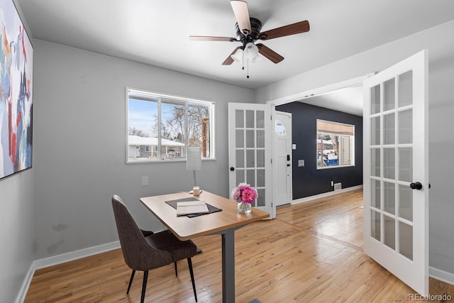 office with ceiling fan, french doors, and light hardwood / wood-style floors