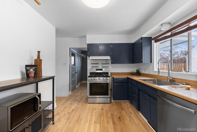 kitchen featuring blue cabinetry, sink, light hardwood / wood-style flooring, and stainless steel appliances