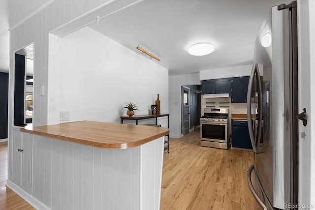 kitchen featuring kitchen peninsula, light wood-type flooring, a breakfast bar, and appliances with stainless steel finishes