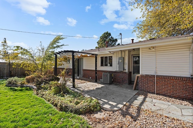 rear view of house with central AC, a pergola, and a yard