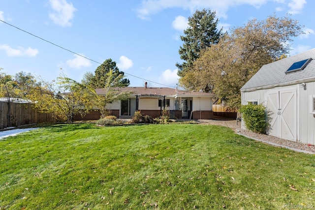 back of property featuring a lawn and an outdoor structure