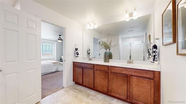 bathroom featuring ceiling fan, a shower with shower door, and vanity