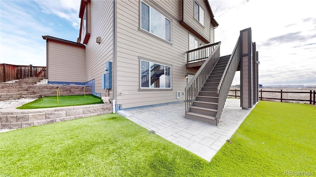 back of house with a lawn and a patio