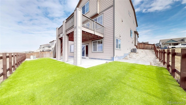 rear view of property featuring central AC, a patio area, and a lawn