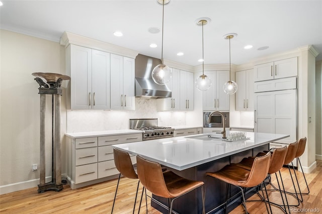 581 Garfield St, Denver, CO 80206 - kitchen with wall chimney exhaust hood, stove, ornamental molding, light wood-type flooring, and a kitchen bar