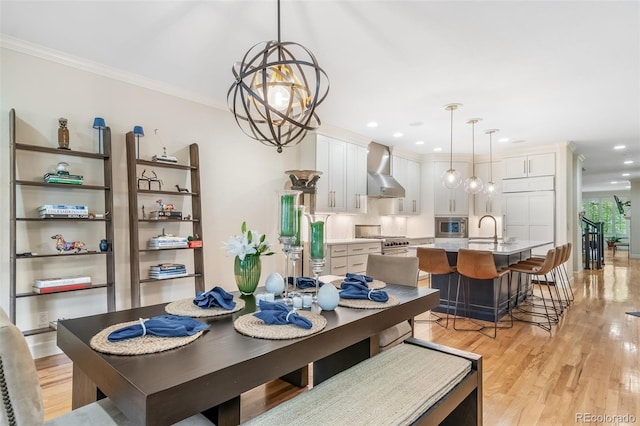 581 Garfield St, Denver, CO 80206 - dining space featuring light wood finished floors, a chandelier, crown molding, and recessed lighting