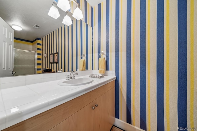 581 Garfield St, Denver, CO 80206 - bathroom featuring wallpapered walls, vanity, and a stall shower