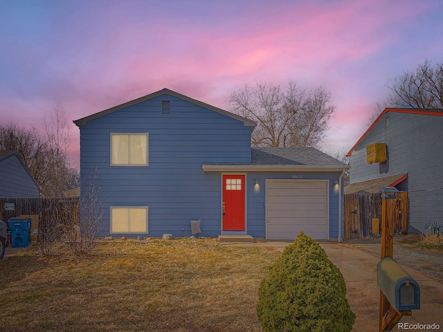 view of front of house featuring a front lawn, driveway, an attached garage, and fence