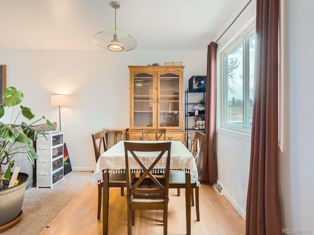 dining room with visible vents, light wood finished floors, and baseboards