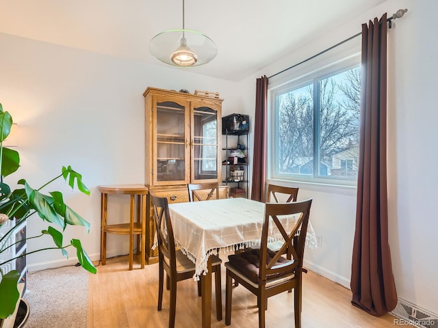 dining area with baseboards, visible vents, and light wood-style flooring