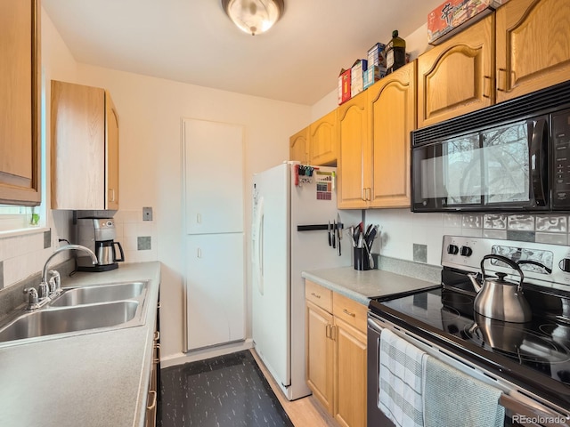 kitchen with decorative backsplash, freestanding refrigerator, stainless steel range with electric cooktop, a sink, and black microwave