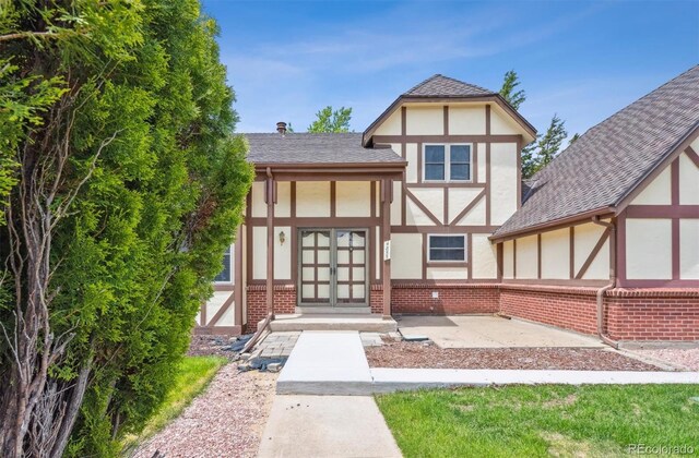 4855 S Joplin St, Aurora, CO 80015 - tudor house with stucco siding, brick siding, french doors, and a shingled roof