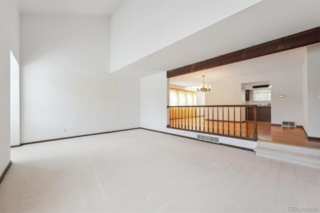 4855 S Joplin St, Aurora, CO 80015 - unfurnished living room featuring a chandelier, carpet flooring, baseboards, and a high ceiling