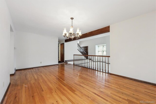 4855 S Joplin St, Aurora, CO 80015 - unfurnished room featuring a chandelier, wood finished floors, and baseboards