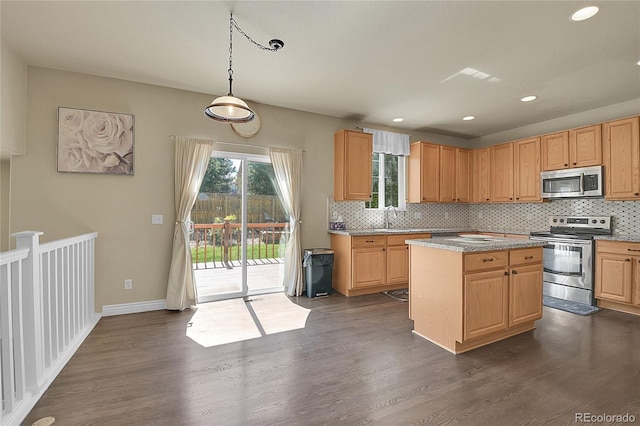 kitchen featuring appliances with stainless steel finishes, dark wood-style flooring, a sink, and decorative backsplash